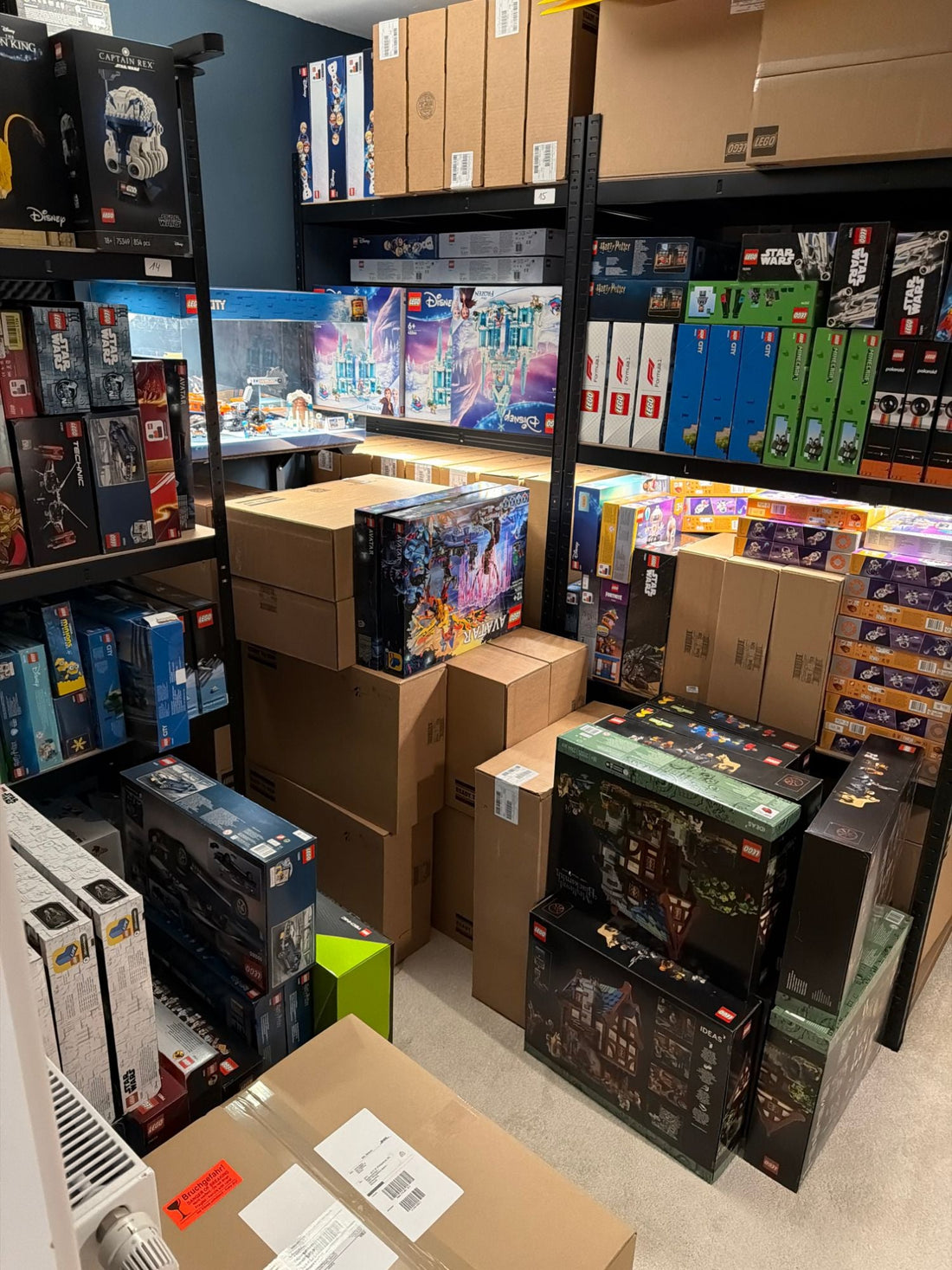Neue, originalverpackte LEGO Sets sortiert in Regalen und Kartons im Lager nach dem Ankauf